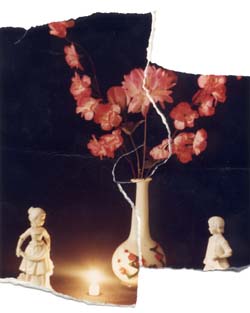 Vase avec fleurs rouges et personnages miniatures en porcelaine. Image déchirée.