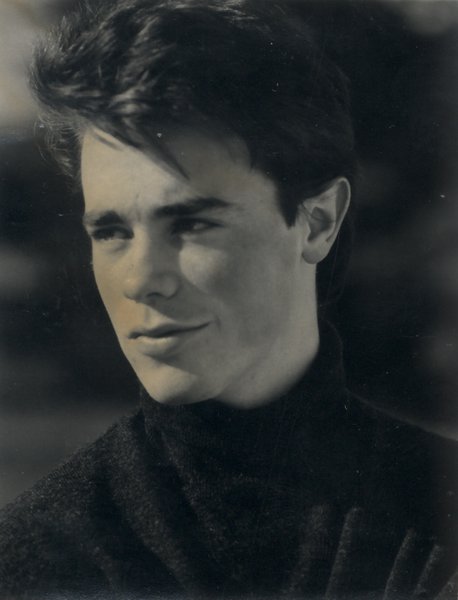 Visage de jeune homme brun de trois quarts avec un pull noir. Noir et blanc.