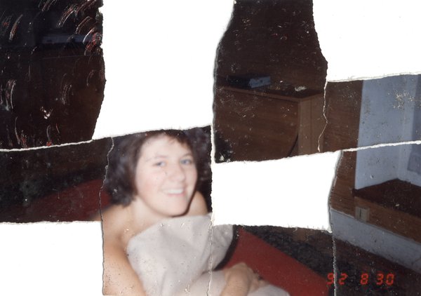 Jeune femme enveloppée dans une serviette, souriante, à l'intérieur. Image avec déchirure, reconstituée.ᴬᴵ