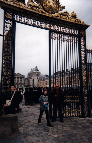 Grille de la cour  pavée du château de Versailles et touristes.