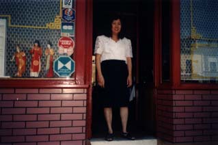 Femme brune debout dans l’entrée d’un restaurant.