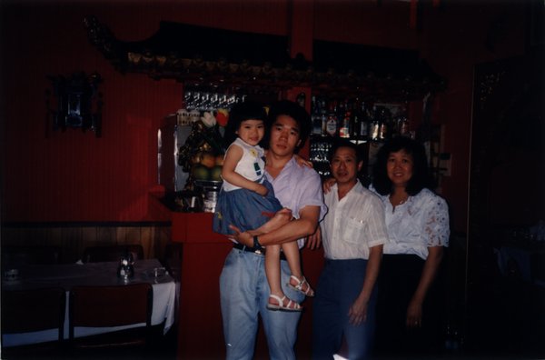 Hommes, femmes, et enfants devant le comptoir d’un bar.