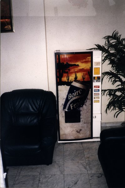 Fauteuil en cuir noir et distributeur automatique de boissons fraîches.