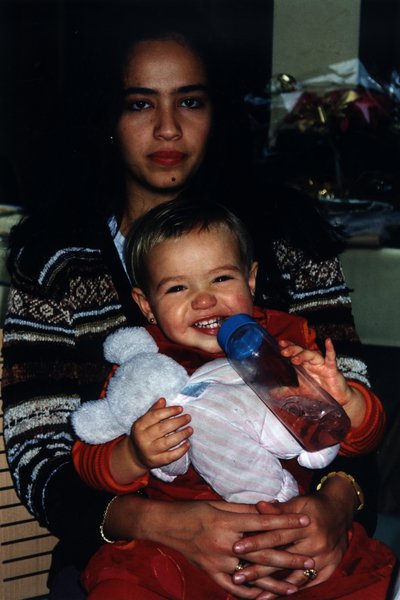 Jeune femme brune avec un petit enfant  sur les genoux.