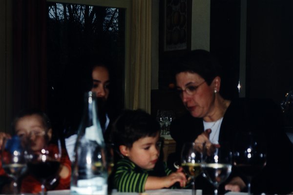Une femme et des enfants assis à une table où sont posés des verres.
