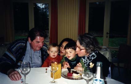 Homme, femme, et enfants assis devant un goûter d’anniversaire.