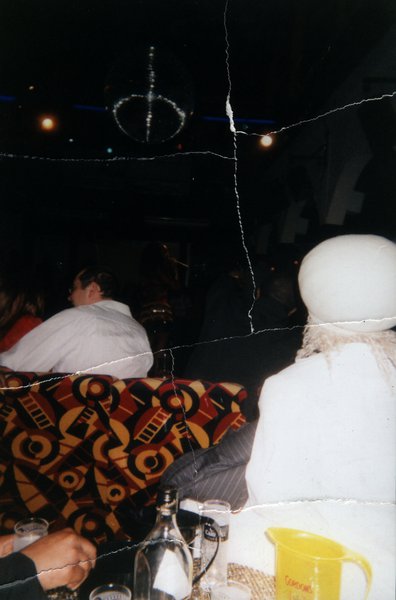 Scène de boîte de nuit avec boule à facettes et convives attablés. Image avec déchirure, reconstituée.ᴬᴵ