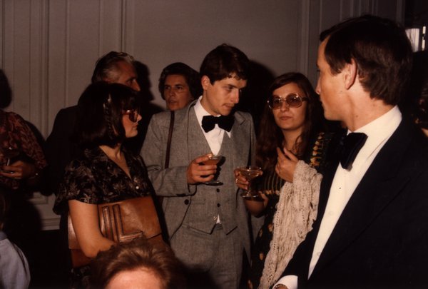 Groupe d'invités en tenue de soirée discutant, verres à la main.ᴬᴵ