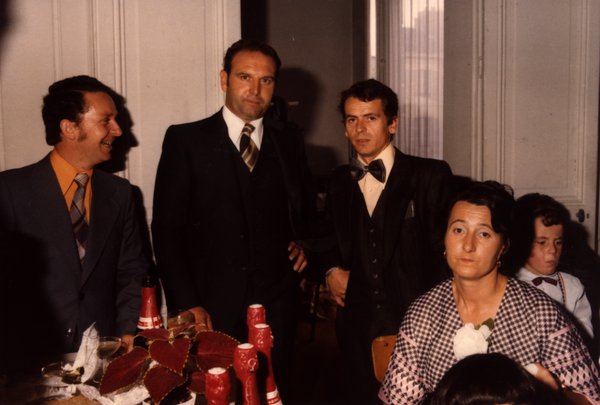Trois hommes en costume debout près d'une table avec des gâteaux en forme de cœur.ᴬᴵ