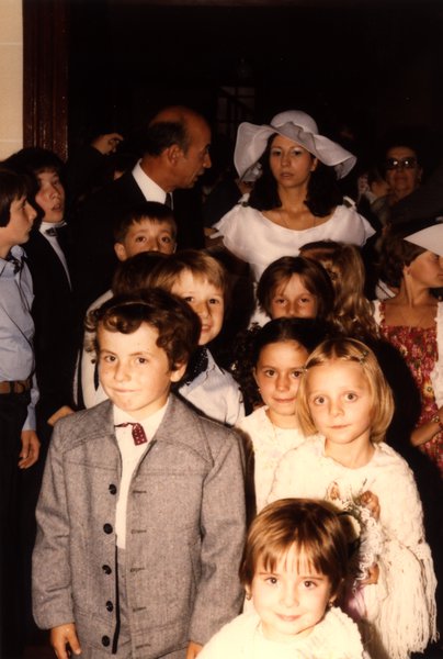 Groupe d'enfants et la mariée réunis près d'une porte.ᴬᴵ