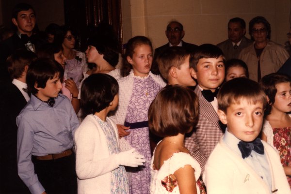 Groupe d'enfants en tenue de cérémonie à l'intérieur.ᴬᴵ