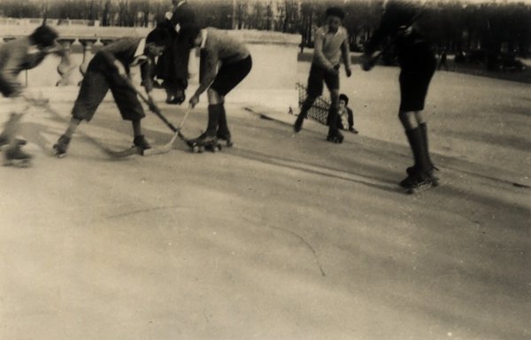 Joueurs de hockey sur patins à roulettes devant un bâtiment orné. Noir et blanc.ᴬᴵ