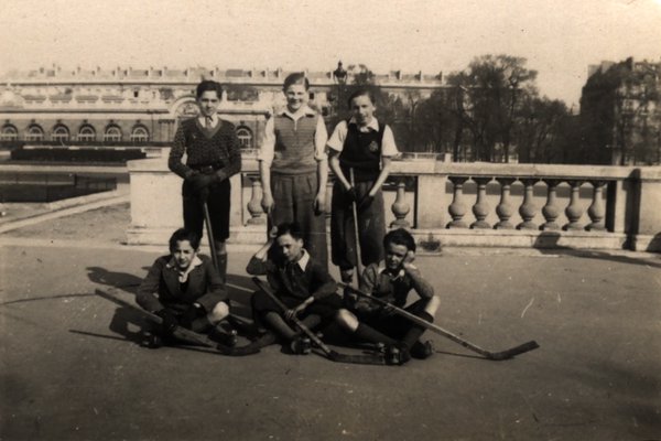 Équipe de hockey sur patins à roulettes posant avec leurs crosses. Noir et blanc.ᴬᴵ