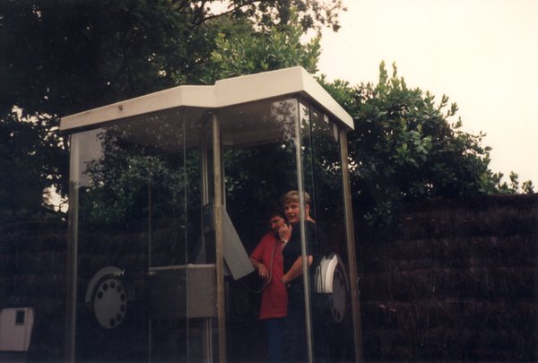 Deux femmes dans une cabine téléphonique.