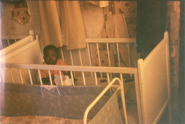 Enfant assis dans un lit-cage.