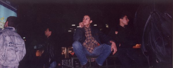 Deux jeunes hommes assis sur une balustrade de nuit.