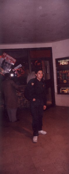 Jeune homme debout à l’entrée d’un restaurant.