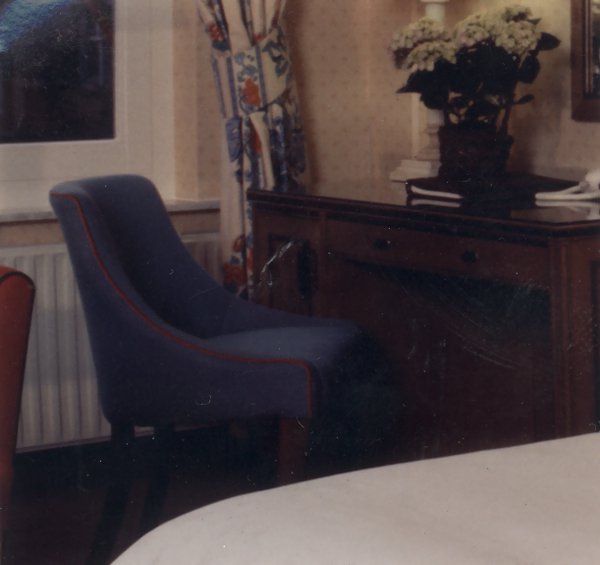 Chambre avec fauteuil et bureau.