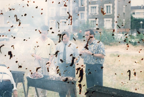 Hommes debout devant des barbecues. Image abîmée.