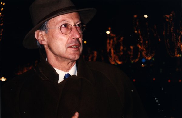 Homme avec chapeau et lunettes de nuit, lumières floues en arrière-plan.ᴬᴵ