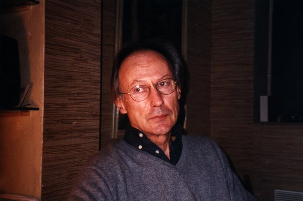 Homme à lunettes regardant l'objectif, intérieur.ᴬᴵ