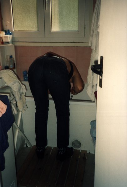 Femme penchée en avant vue de dos dans une salle de bain.ᴬᴵ