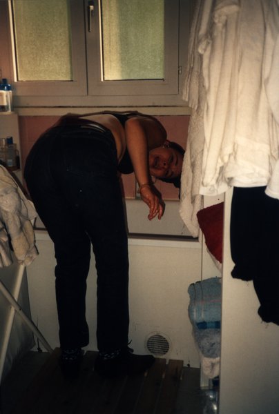 Femme penchée en avant, visage reflété dans un miroir de salle de bain.ᴬᴵ