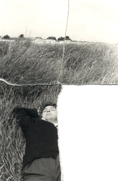 Homme allongé dans de grandes herbes. Image déchirée en partie reconstituée. Noir et blanc.