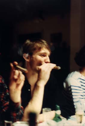 Repas avec un homme châtain avec un cigare au milieu d’autres convives fumant le cigare.