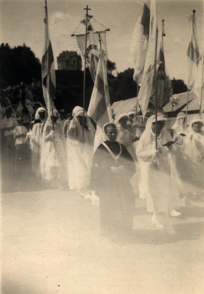 Procession religieuse avec bannières et femmes en voile blanc. Photo ancienne sépia.ᴬᴵ