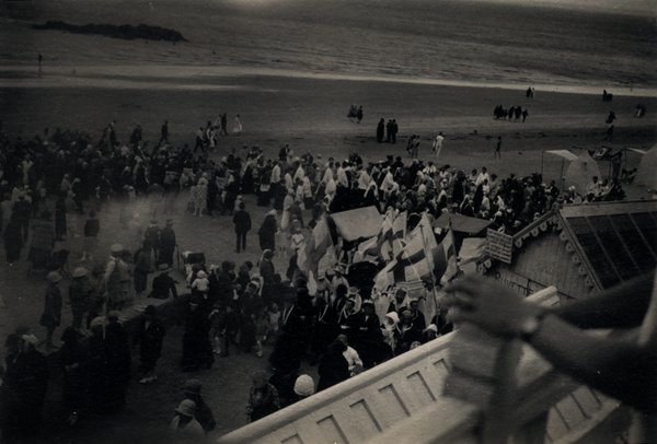 Vue en hauteur d'une plage bondée pendant une procession. Photo ancienne sépia.ᴬᴵ