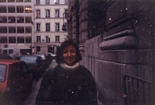 Femme souriante dans une rue de Paris.
