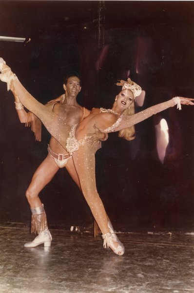 Danseuse de revue en grand écart dans les bras d’un danseur.