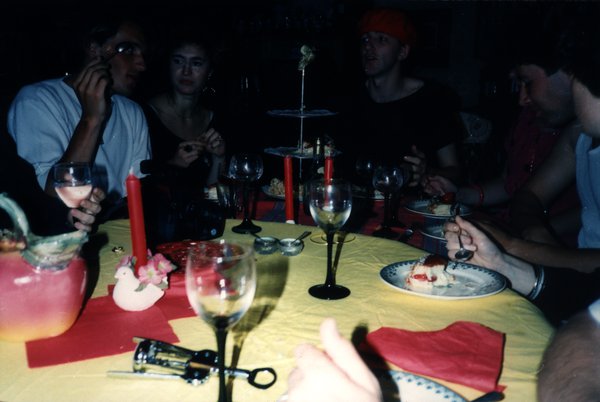 Groupe attablé autour de bougies et de verres de vin lors d'un dîner.ᴬᴵ