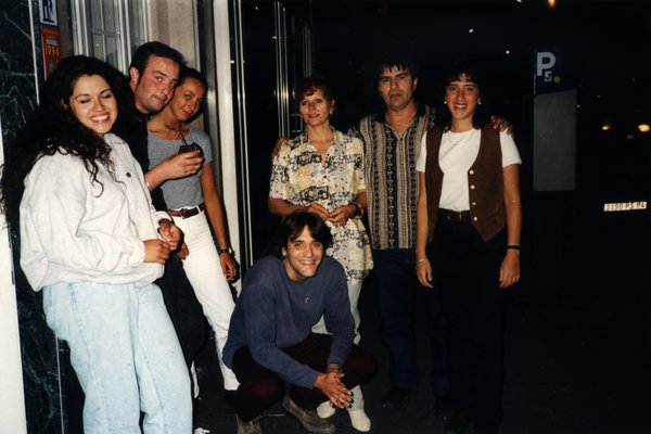 Groupe de sept personnes posant dans une rue de nuit.ᴬᴵ
