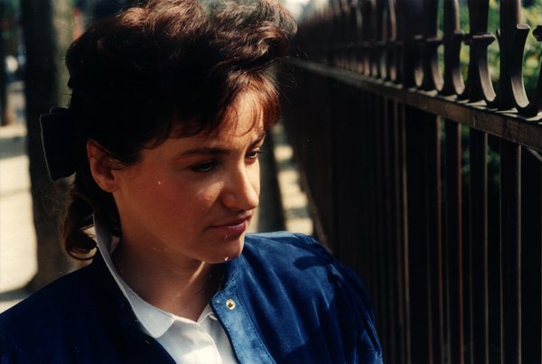 Portrait d'une femme en veste bleue, cheveux attachés d'un nœud.ᴬᴵ