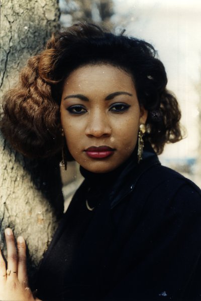 Portrait d'une femme aux cheveux bouclés et boucles d'oreilles dorées.ᴬᴵ