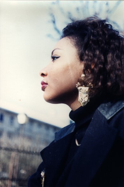 Portrait de profil d'une femme aux cheveux bouclés portant de grandes boucles d'oreilles.ᴬᴵ