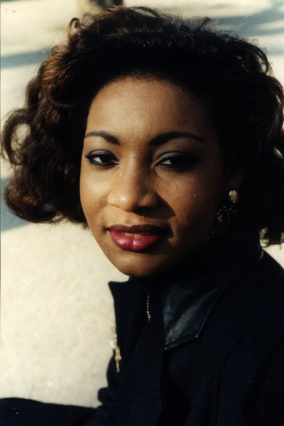 Portrait d'une femme aux cheveux bouclés souriant légèrement, neige en arrière-plan.ᴬᴵ