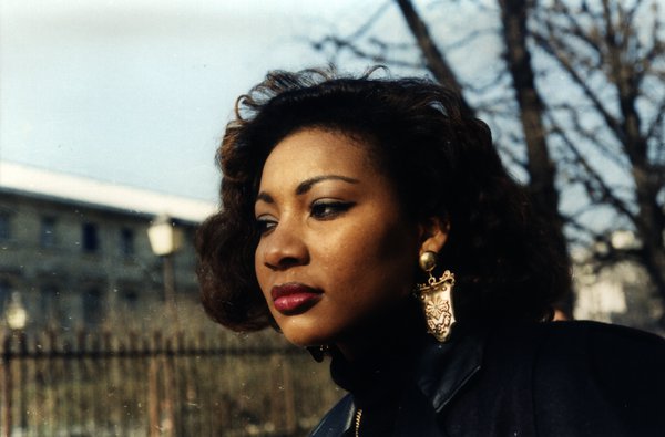 Portrait de profil d'une femme aux cheveux bouclés dans un parc.ᴬᴵ