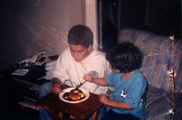 Deux enfants mangeant un gâteau à une petite table.ᴬᴵ