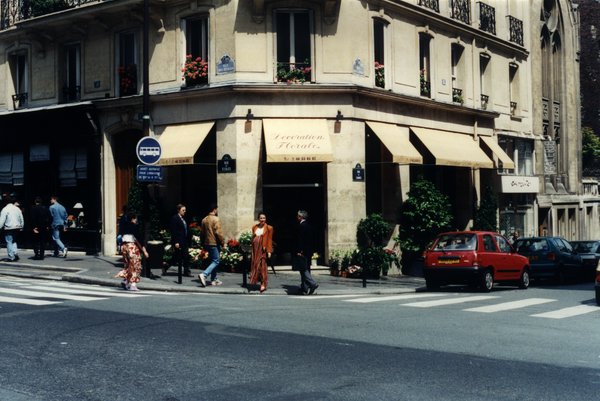 Magasin de fleurs au coin d’une rue parisienne et passage piéton.