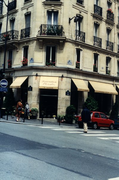 Magasin de fleurs au coin d’une rue parisienne et passage piéton.
