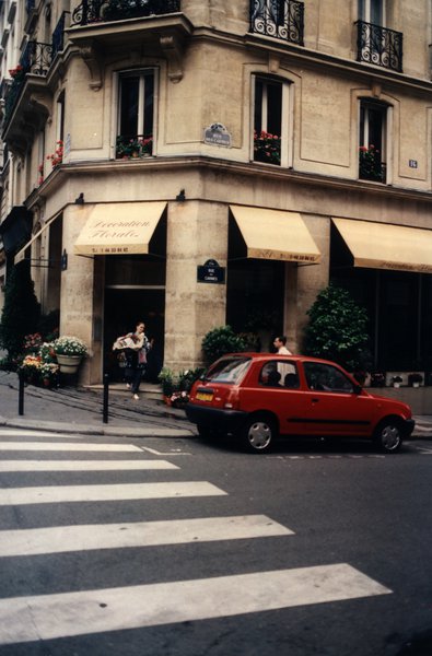 Magasin de fleurs au coin d’une rue parisienne et passage pieton.