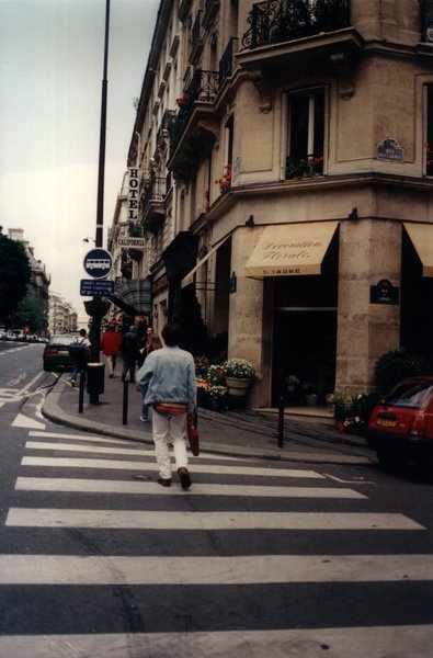 Magasin de fleurs au coin d’une rue parisienne, passage pieton et passants.