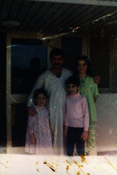 Famille de quatre personnes devant une maison. Image avec rayures.ᴬᴵ