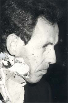 Visage d’homme brun de profil. Image abîmée.