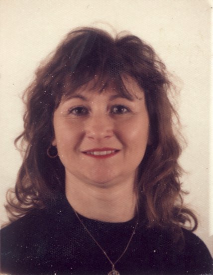 Visage de femme à cheveux châtain clair souriante.