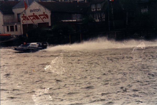 Bateau de course passant devant un club d'aviron.ᴬᴵ