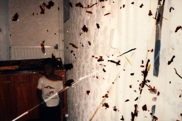 Enfant debout dans une pièce. Image avec taches sombres.ᴬᴵ